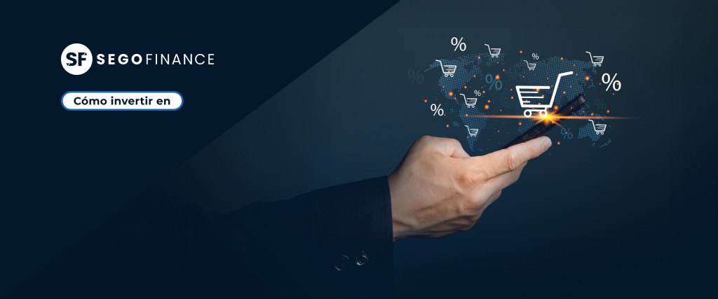 cabecera-como-invertir-en-sector-ecommerce Mano sosteniendo un smartphone con iconos de carrito de compra y porcentajes, representando inversión en el sector e-commerce. Imagen corporativa de SEGOFINANCE con título “Cómo invertir en”.