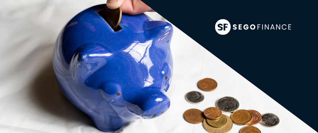 Imagen entradas blog (9) Mano introduciendo moneda en hucha azul, concepto de ahorro e inversión en SEGOFINANCE