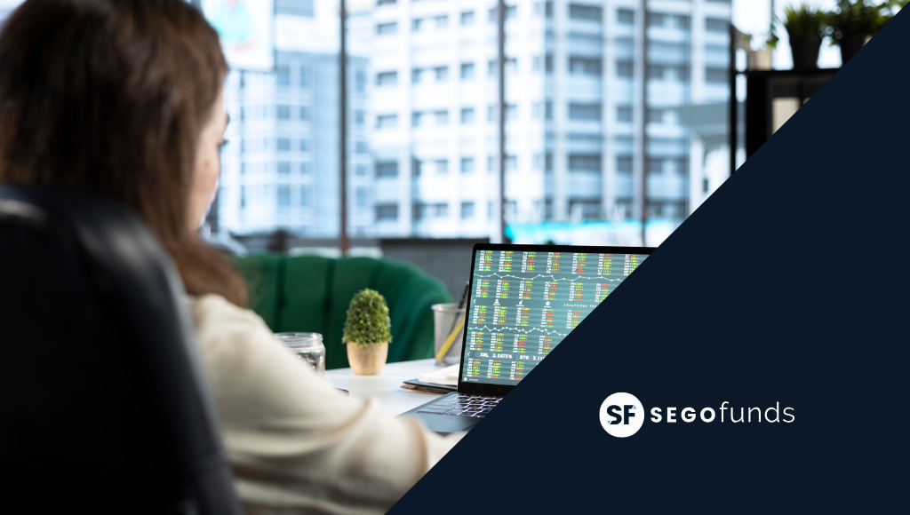 Persona analizando datos financieros en portátil con gráficos bursátiles en oficina moderna, imagen corporativa de Segofunds.