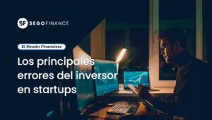 Imagen de un escritorio con varias pantallas mostrando gráficos financieros, acompañada del título ‘Los principales errores del inversor en startups’ dentro de la sección El Rincón Financiero de SEGOFINANCE