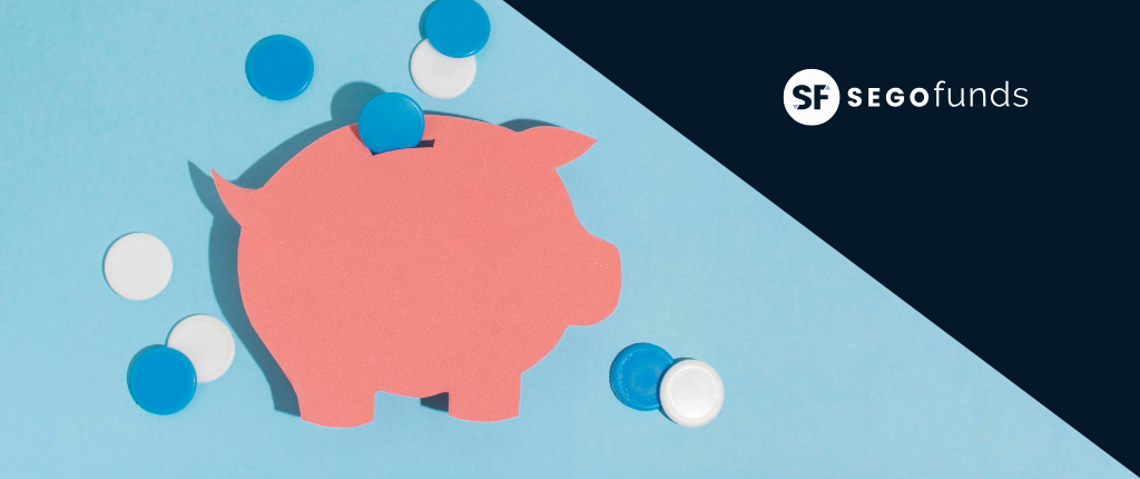Hucha rosa con monedas azules y blancas representando el ahorro e inversión en mercados financieros con SEGO Funds